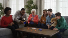 Family playing a dice-rolling game on a living room table