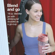 Coral personal blender with travel lid held by a person