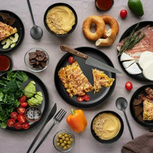 Black dinner plates and bowls with cutlery and assorted plated foods