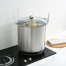 Water bath canner pot with lid holding filled jars on a stovetop