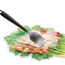 Black silicone spatula lifting grilled meat and vegetables