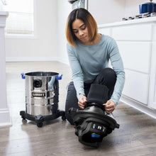 Stainless steel wet/dry vacuum with black hose and floor nozzle, with Hart logo