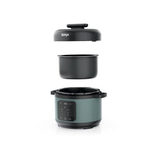 Ninja pressure cooker with lid removed, sage green body and black inner pot