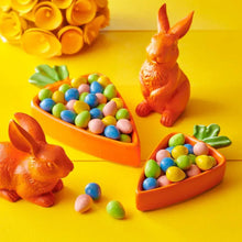Hand-shaped bowls of multicolored candy eggs and pieces with two bunny figures