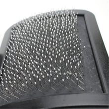 Close-up of black slicker brush pad with metal pins