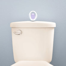 Oval plug-in air freshener unit with lavender fragrance opening on toilet lid