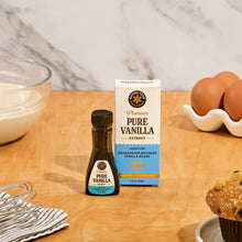 Pure vanilla extract bottle and carton on a countertop near baking ingredients