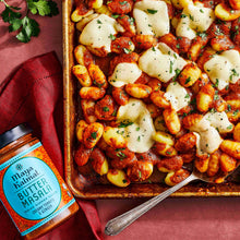 Butter masala simmer sauce jar with baked bites topped with herbs