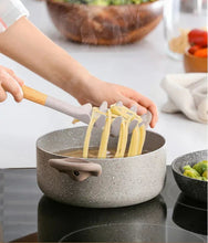 Pasta serving utensils with silicone ends and bamboo handles in a pot