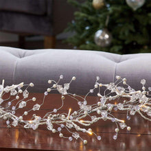 LED gem garland with clear bead strands and small warm-white lights, looped in a wave