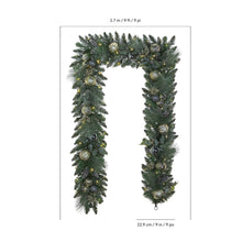 Pre-lit artificial garland with dark green needles and metallic ornaments in an arch shape