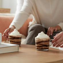 Dessert coffee cups with whipped cream and chocolate-striped drizzle