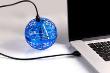 Blue spherical hover ball with grid design and power cord on a desk