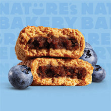 Blueberry fig bars stacked, with whole blueberries beside them