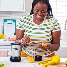 Countertop blender with clear mixing cup and black base, filled with smoothie