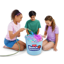 Kids filling a bucket with self-sealing water balloons using a hose