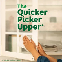 Paper towel roll being pulled by hands over kitchen counter