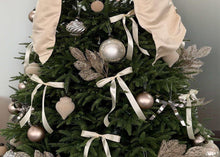 Champagne Christmas tree decorations with bows, ribbon streamers, and assorted bauble ornaments.
