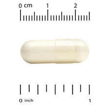 Two white veggie capsules on a ruler scale