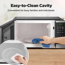 BLACK+DECKER microwave oven with open cavity and hand wiping interior