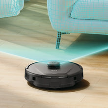 Robot vacuum on hardwood floor near bed, with top status light on