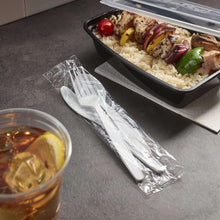 Clear plastic-wrapped utensils with forks, spoons, and knives beside takeaway meal