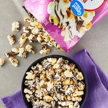 Black and white drizzle popcorn in bowl with chocolate and white drizzle