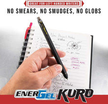 Hand holding black EnerGel Kuro gel pen over spiral notebook notes