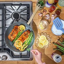 Black non-stick ceramic fry pan on stove, wood handle