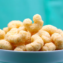 Salt and pepper puffed snack pieces with a light, airy texture.