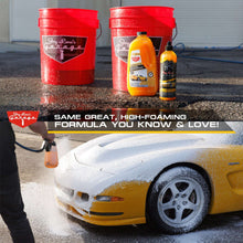 Car wash kit detailing bottles and red buckets with foaming spray on car