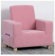 Kids upholstered armchair, pink fabric, side view with small label on arm, wooden legs.