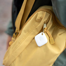White Tile Mate tracker hanging from a bag zipper pull.