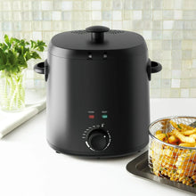 Matte black electric deep fryer with lid and temperature control dial