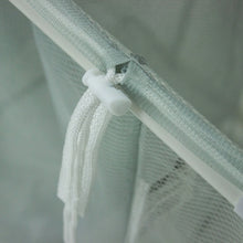 Mesh bin edge tie with white cord on the corner of a laundry sorter cart