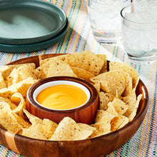 Wood bowl of cheddar dip with tortilla chips and a small cup of dip