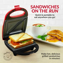 Red mini sandwich maker grill with two sandwiches on a plate