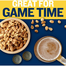 Roasted peanuts in a wooden bowl with drink cup and bottle caps