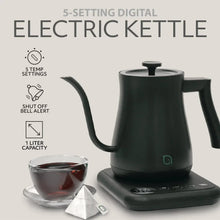 Electric gooseneck kettle with base and cup of tea beside it