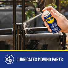Hand spraying WD-40 multi-use spray can onto an outdoor metal chair frame