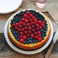 White dinner plate with fruit-topped cheesecake