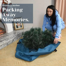 Blue Christmas tree storage bag with tree inside and black carrying straps