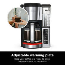 Black and stainless coffee maker showing adjustable warming plate and glass carafe