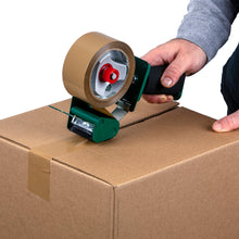 Tan packaging tape roll on a handheld dispenser, sealing a cardboard box