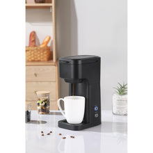 Black matte single-serve coffee maker with white mug on drip tray