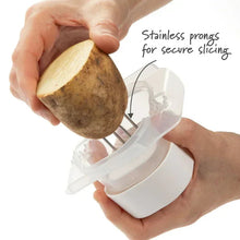 White multi slicer with clear lid and stainless prongs holding a potato