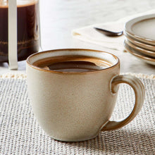 Stoneware coffee mug in speckled cream, visible interior and curved side handle