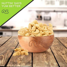 Salted roasted cashews in terracotta-style bowl with a few scattered nuts