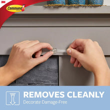Clear Command clip pressed onto a wall by hands