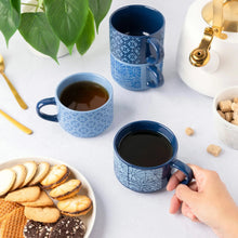 Blue patterned stacking mugs, two filled drinks shown with hands
